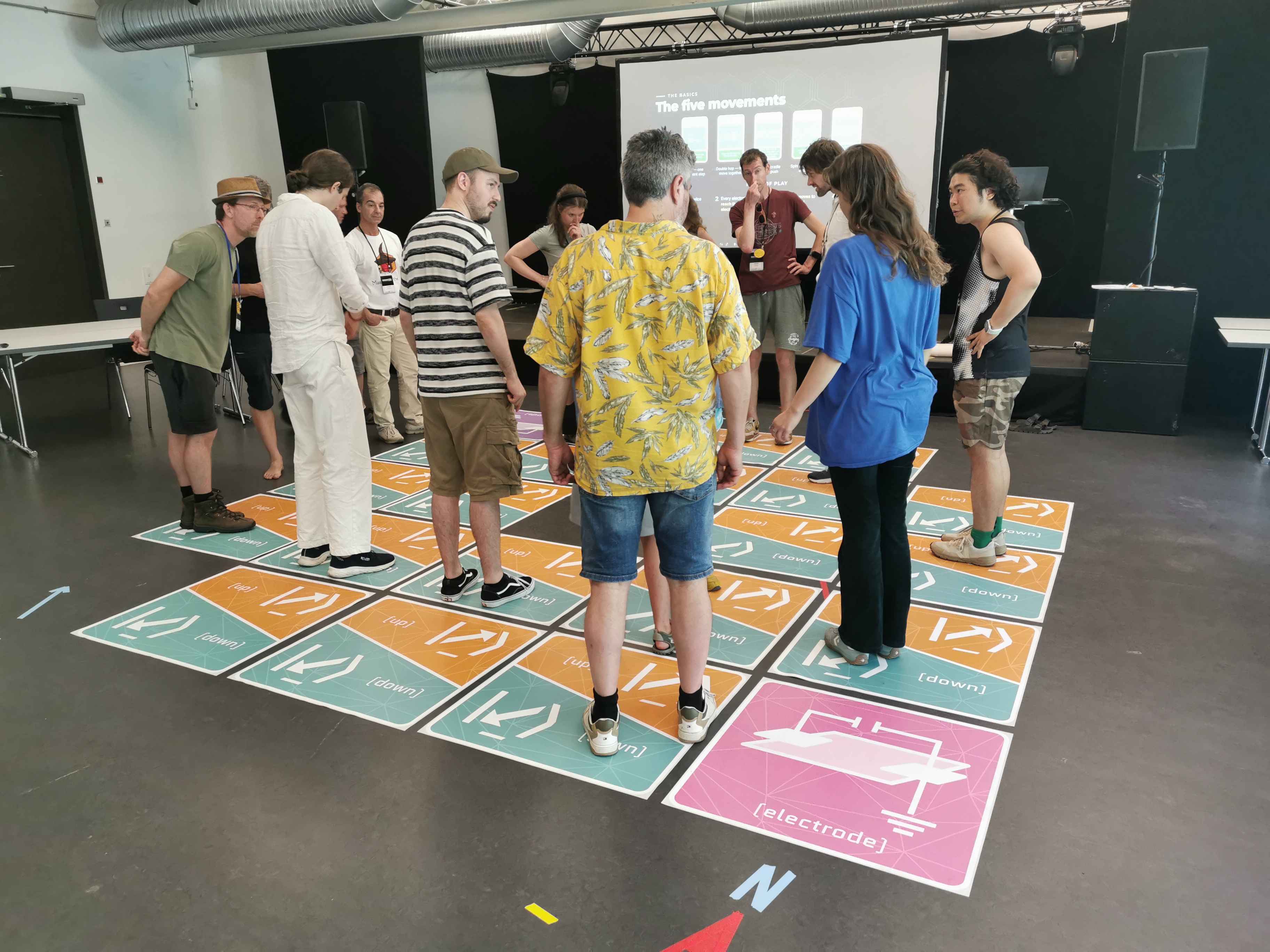 Participants gathered in a circle around the game board, discussing their moves as one team